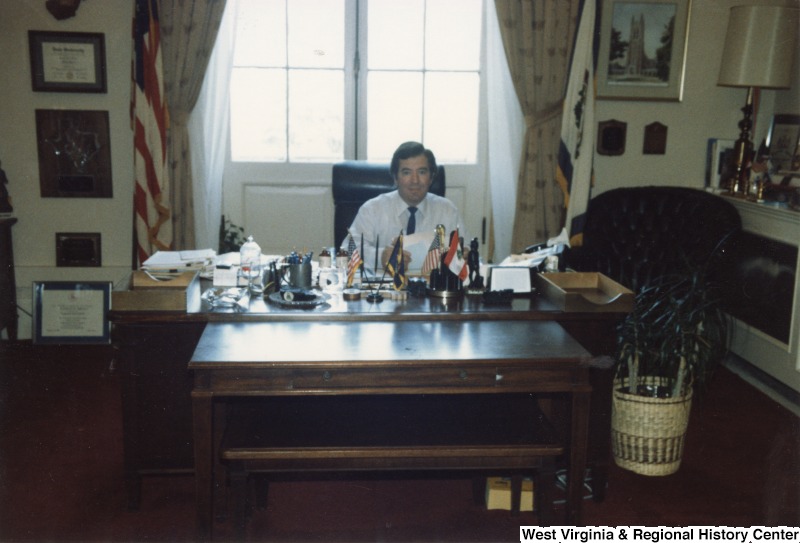 Representative Nick J. Rahall (D-W.Va.) sits behind a desk.
