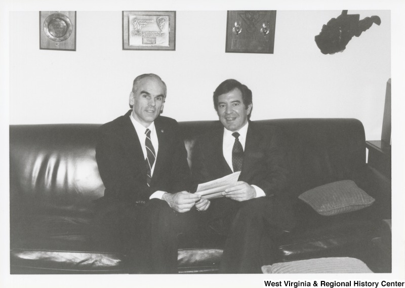 Secretary Donald P. Hodel sits on a couch and looks over papers with Representative Nick J. Rahall (D-W.Va.).