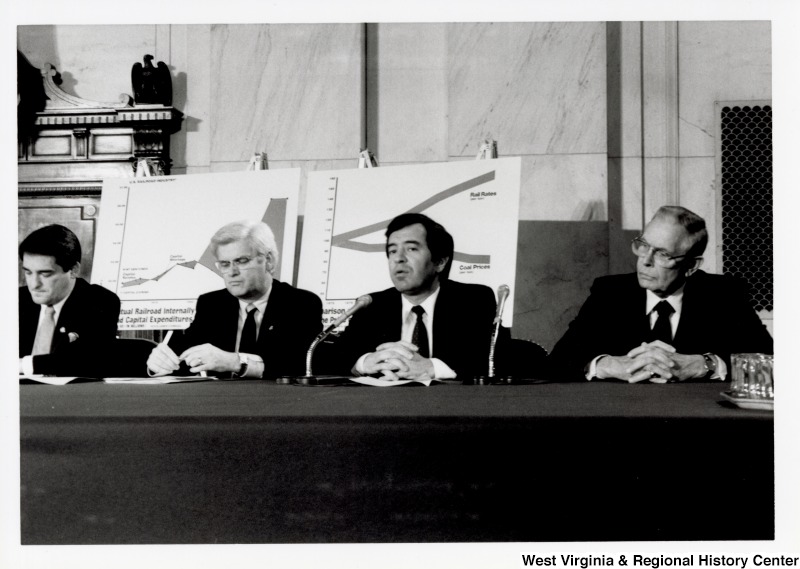 Second from the right, Representative Nick J. Rahall (D-W.Va.) sits at a panel with three unidentified men.