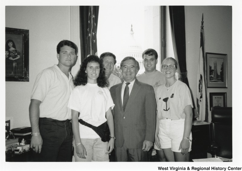 Representative Nick J. Rahall (D-W.Va.) stands for a photograph with five unidentified people in his office.