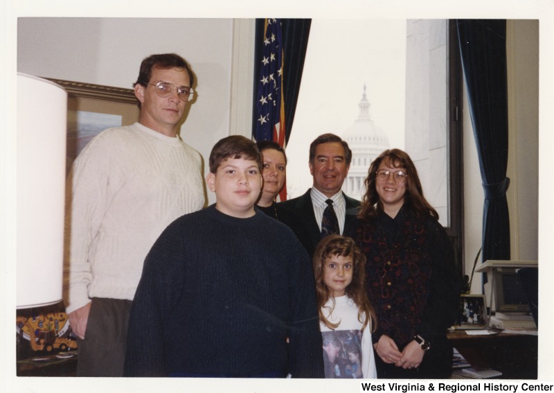 Representative Nick J. Rahall (D-W.Va.) stands in between five unidentified people in his office.