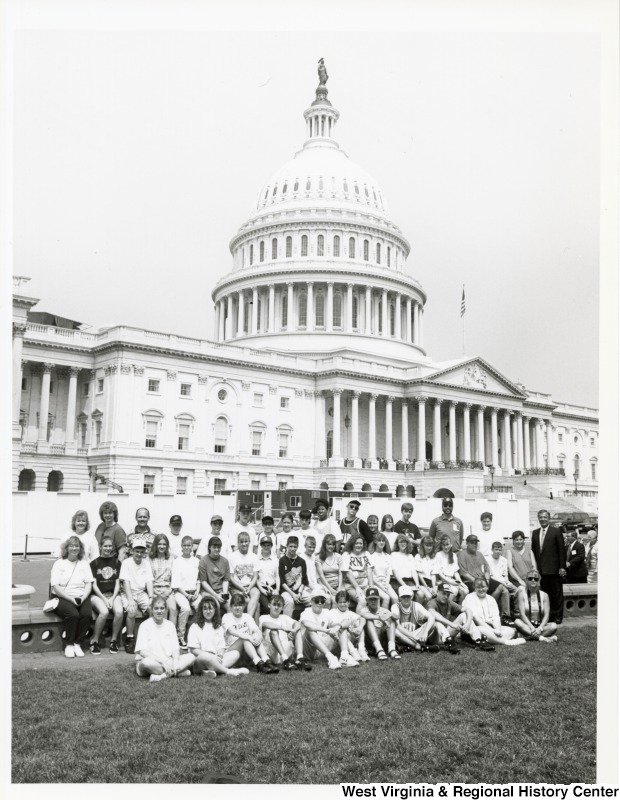 On the far right, Representative Nick J. Rahall (D-W.Va.) stands with a group of unidentified students in front of the Capitol building.