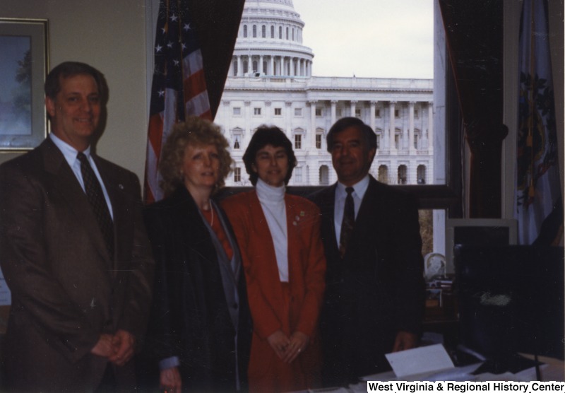 On the far right, Representative Nick J. Rahall (D-W.Va.) stands in his office with two unidentified women and an unidentified man.