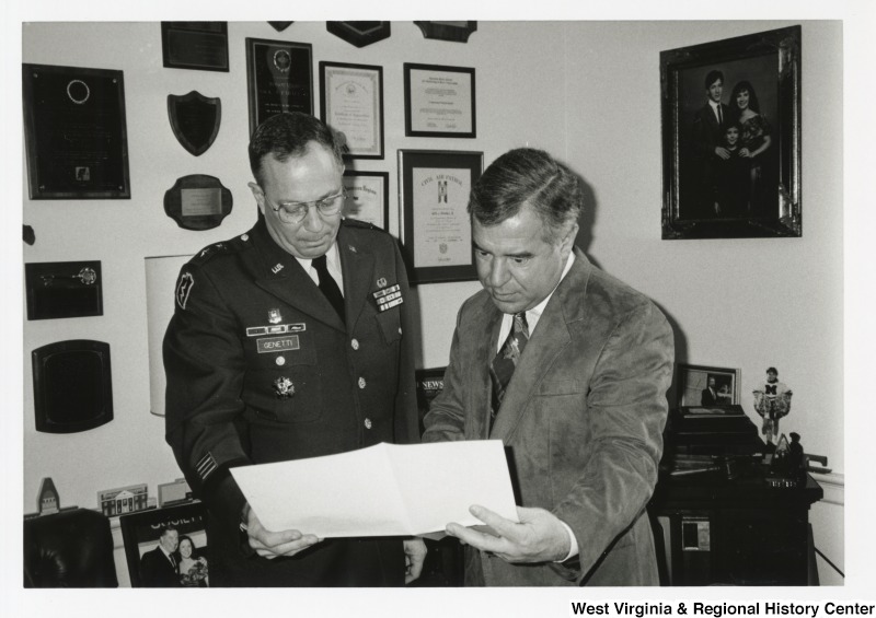 Representative Nick J. Rahall (D-W.Va.) looks over a paper with Major General Albert Genetti.