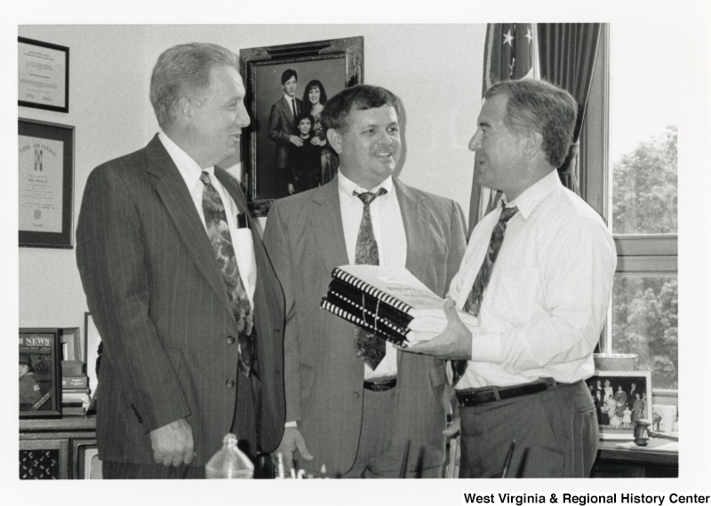 Representative Nick J. Rahall (D-W.Va.) holds the County Development Accepting Economic Development Zone package with Mingo County Commissioners Curt Fletcher & Mike Whitt.