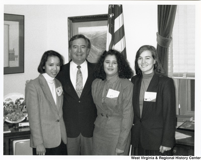 Representative Nick J. Rahall (D-W.Va.) stands for a photograph between three unidentified young women.