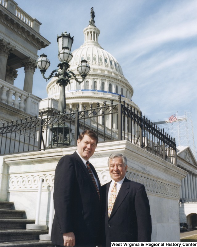 On the right, Representative Nick J. Rahall (D-W.Va.) stands for a photograph in front of the Capitol building with Dr. Dan Angel, the president of Marshall University.