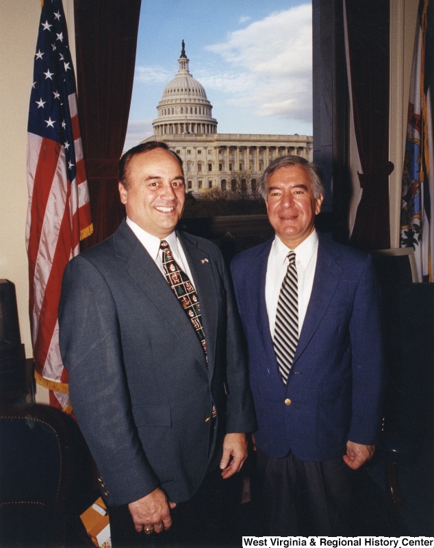 On the right, Representative Nick J. Rahall (D-W.Va.) stands for a photograph in his office with an unidentified man.
