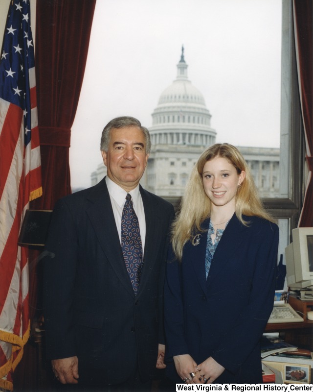 On the left, Representative Nick J. Rahall (D-W.Va.) stands for a photograph in his office with an unidentified woman.