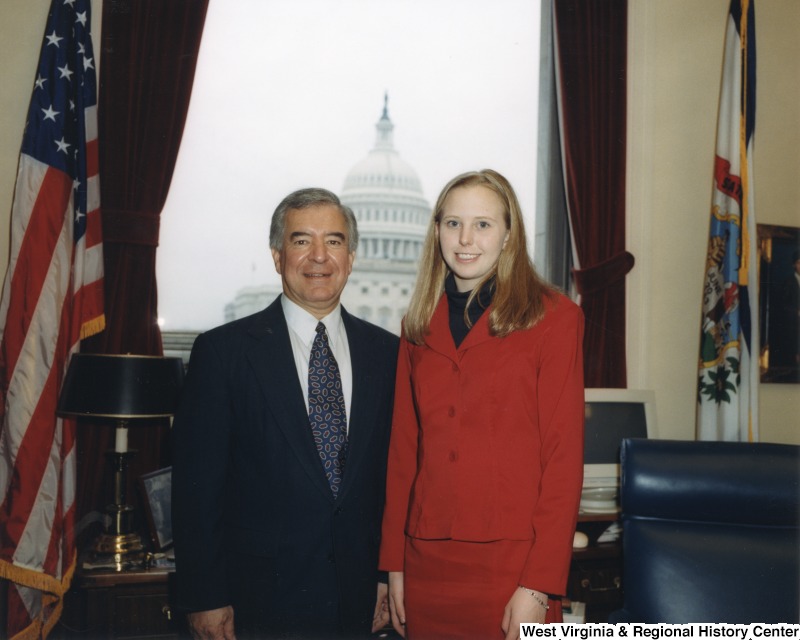 On the left, Representative Nick J. Rahall (D-W.Va.) stands for a photograph in his office with an unidentified woman.