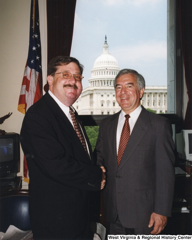 On the right, Representative Nick J. Rahall (D-W.Va.) shakes hands for a photograph with Delegate Randy White (D-W.Va.).