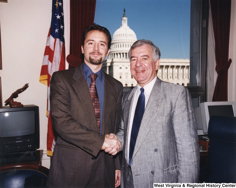 On the right, Representative Nick J. Rahall (D-W.Va.) shakes hands with Tom Attar for a photograph.