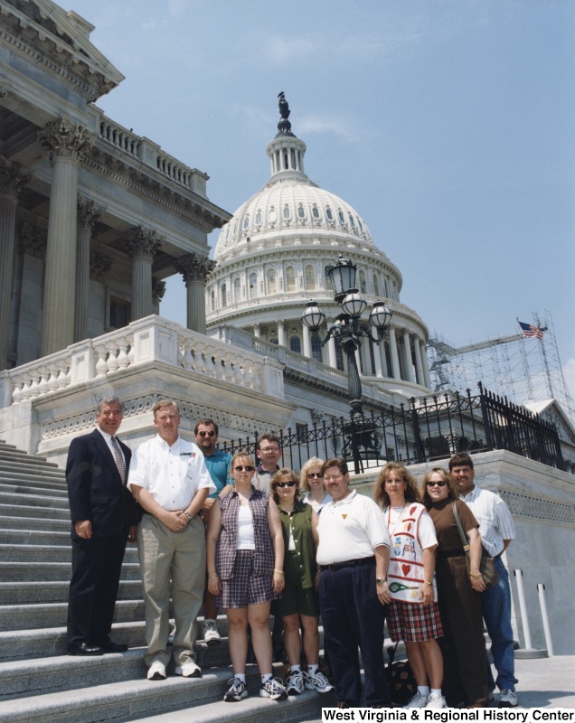 On the left, Representative Nick J. Rahall (D-W.Va.) stands in front of the Capitol building with a group of unidentified people from the Church of God.